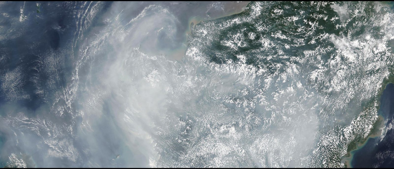 Satellite view of a dense mass of smoke haze over West Kalimantan, Borneo, streaming west across the South China Sea.